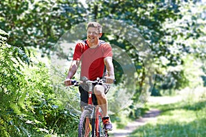 Active Man Cycling Along Path In Countryside