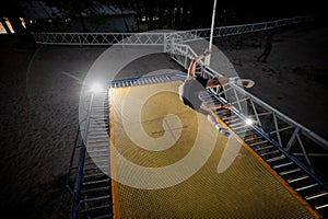 Active man dressed in sporty clothes jumping on a trampoline