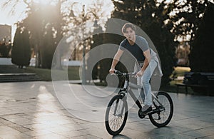 Active man enjoying a peaceful ride on his bicycle in a sunny park