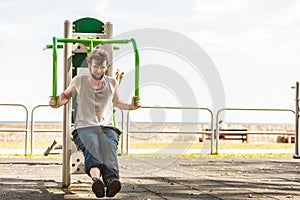 Active man exercising on chest press outdoor.