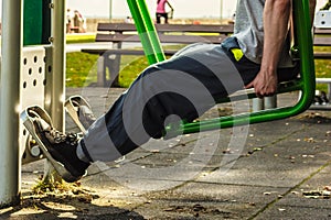 Active man exercising on leg press outdoor.