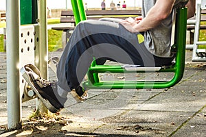 Active man exercising on leg press outdoor.