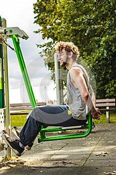 Active man exercising on leg press outdoor.