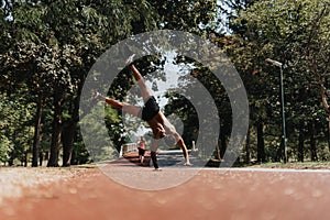 Active man of fit athletes practice cartwheels in sunny park, inspiring motivation and showcasing results of physical