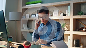 Active man holding telephone call workplace. Designer typing computer keyboard