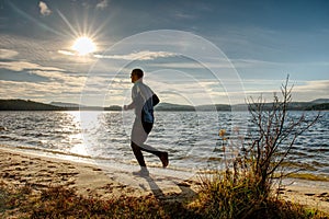 Active Man running at lake. Travel adventure healthy lifestyle concept vacations, athletic person