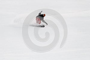 Active man snowboarder roundly descends from the mountain in freeride style