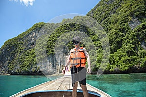 Active man on thai traditional longtail Boat is ready to snorkel and dive, Phi phi Islands, Thailand