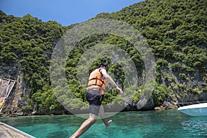 Active man on thai traditional longtail Boat is ready to snorkel and dive, Phi phi Islands, Thailand