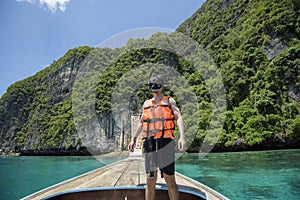 Active man on thai traditional longtail Boat is ready to snorkel and dive, Phi phi Islands, Thailand