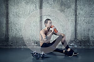 Active man with water bottle and dumbell