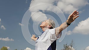 active mature senior woman doing sports, cool down, take deep breath, hands up