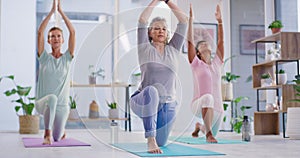 Active mature women meditating during a fitness class in a yoga studio. Yogi training a group of calm, relaxed and