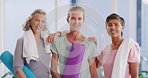 Active mature women ready for a yoga session in a fitness studio. Portrait of a diverse group of confident and smiling