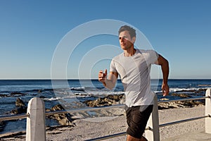 Active middle age man jogging outside by sea