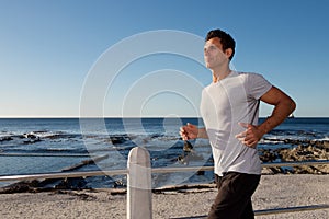 Active middle age man running outside by sea photo
