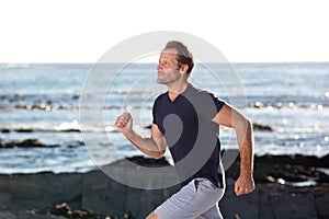 Active middle age man running by the sea