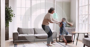 Active middle aged granny dancing barefoot with granddaughter.