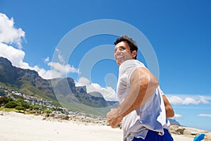 Active middle aged man running on the beach