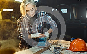 Active Middle aged woman selects wood in workshop. Concept of professionally oriented motivated modern woman. Gender equality,