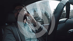 Active and modern successful man sits in the car on the driver`s seat