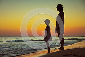 Active mother and child on beach at sunset spending time