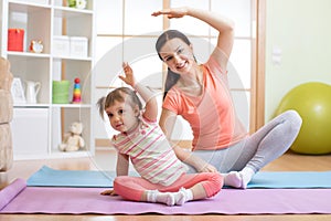 Active mother and child daughter are engaged in fitness, yoga, exercise at home