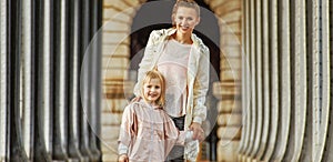 Active mother and daughter standing on Pont de Bir-Hakeim bridge