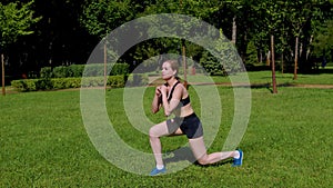 Active motivated sporty fit woman performing jumping lunges exercise in park