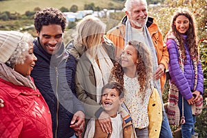 Active Multi-Generation Family On Winter Beach Vacation Resting By Gate