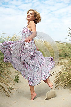 Active older woman dancing at the beach