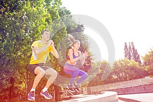 Active people doing box jump exercise outdoors