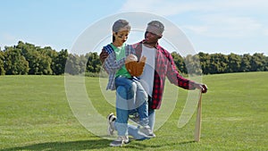 Active positive black father and little son preparing for baseball game outdoor