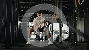 Active powerful muscular fitness instructor Caucasian man sportsman athlete bodybuilder training with battle ropes