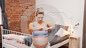 Active pregnancy. Middle-aged soon-to-be-mother exercising joga on her soft mat in her beautiful modern bedroom.