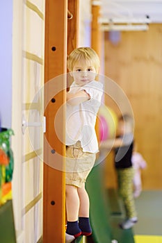 Active preschool boy during lesson in indoor sports hall/gym class