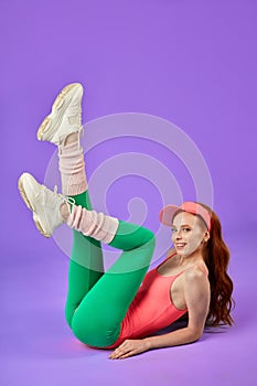 Active pretty young woman watches aerobics training class on TV
