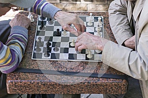 Active retired people, old friends and free time, two seniors having fun and playing chess game at park. Old men are playing chess