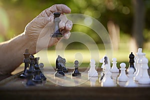 Active retired people, senior man playing chess at park