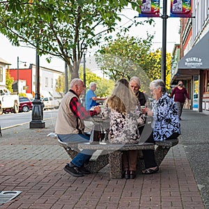 Active retirement, old people and seniors free time, group of four elderly men having fun and playing cards game at park