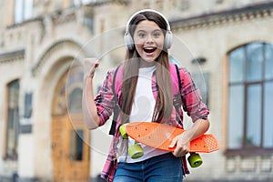 Active ride. Happy girl skater flex arm holding penny board outdoors. Action sport. Recreational activity. Healthy