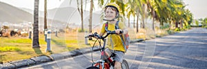 Active school kid boy in safety helmet riding a bike with backpack on sunny day. Happy child biking on way to school