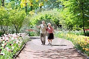 Active senior couple in beautiful flowers park