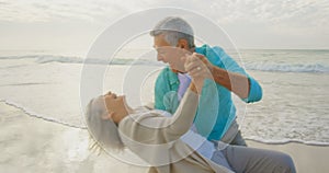 Active senior couple dancing together on the beach 4k