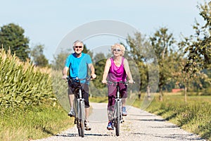 Active senior couple enjoying retirement while riding bicycles i
