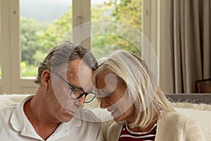 Active senior couple head to head on sofa in a comfortable home