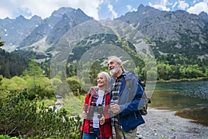 Active senior couple hiking together in autumn mountains.