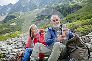 Active senior couple hiking together in autumn mountains.