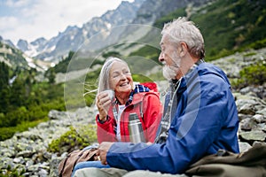 Active senior couple hiking together in autumn mountains.