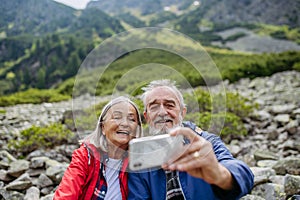 Aktívny starší pár spolu na turistike v jesenných horách.